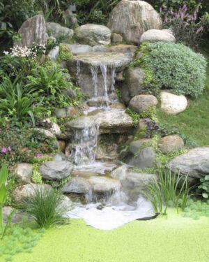 Kleiner Gartenteich mit Wasserfall: Naturstein-Kaskade im Hanggarten